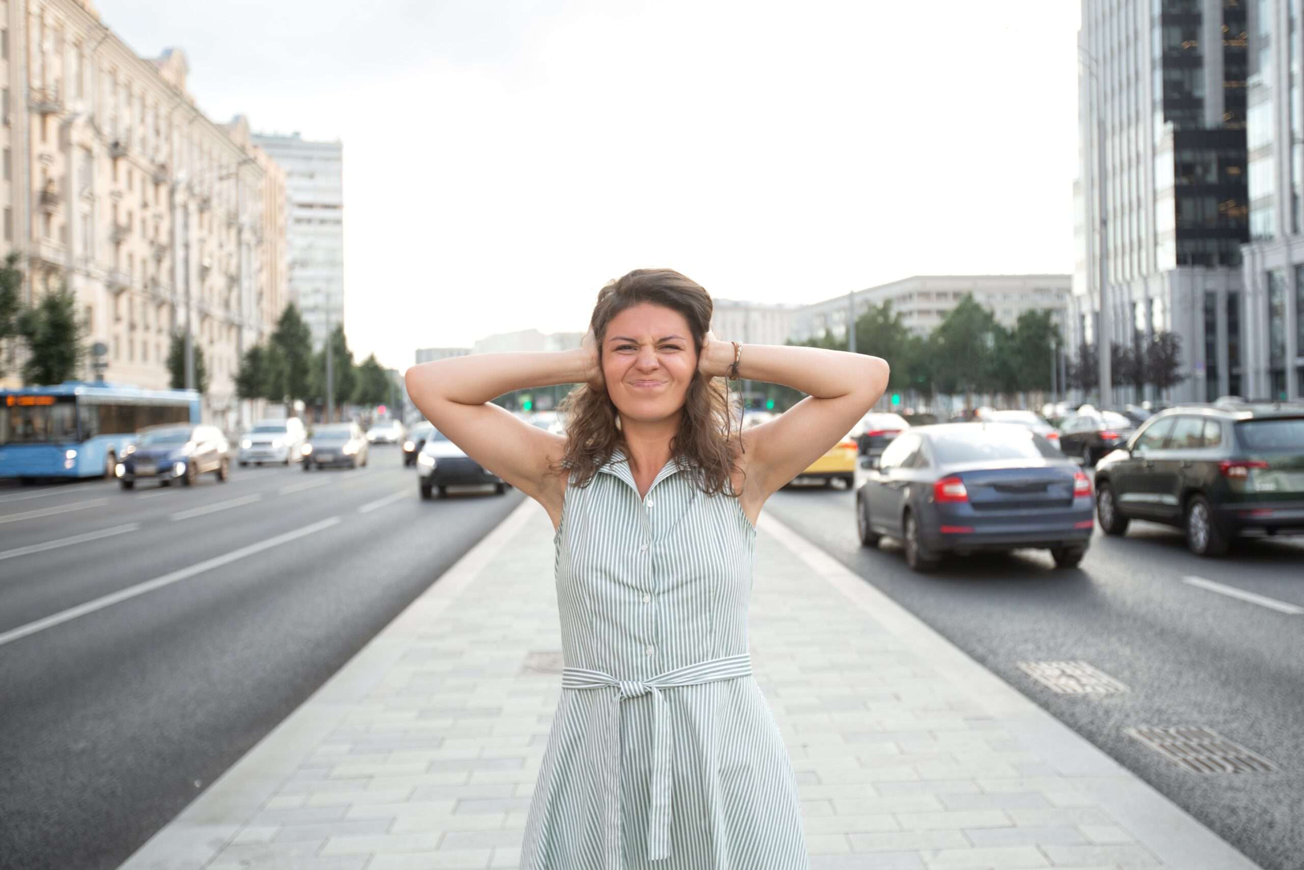 Donna si tappa le orecchie a causa dell'inquinamento acustico